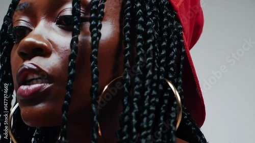 Close-up profile of a passionate female rapper delivering powerful lyrics, highlighting her expressive face and braided hairstyle