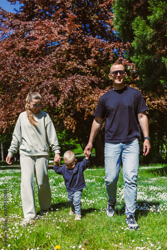 A Family Happily Enjoying a Beautiful Sunny Day Outdoors in a Lovely Park Surrounded by Colorful Trees and Vibrant Greenery, Creating Lasting Memories Together while Bonding and Laughing