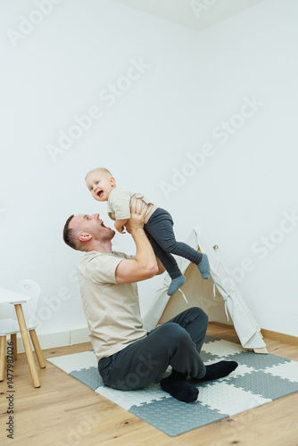 In a cozy living room, a father and his baby share joyful laughter while engaging in playful activities that strengthen their bond and create lasting memories of love and happiness