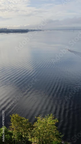 Aerial view of boat crossing Amazon Black River (Rio Negro) with cable-stayed bridge on the background. Ponta Negra Beach, Manaus, Amazonia, Amazonas, Brazil. 4k Vertical