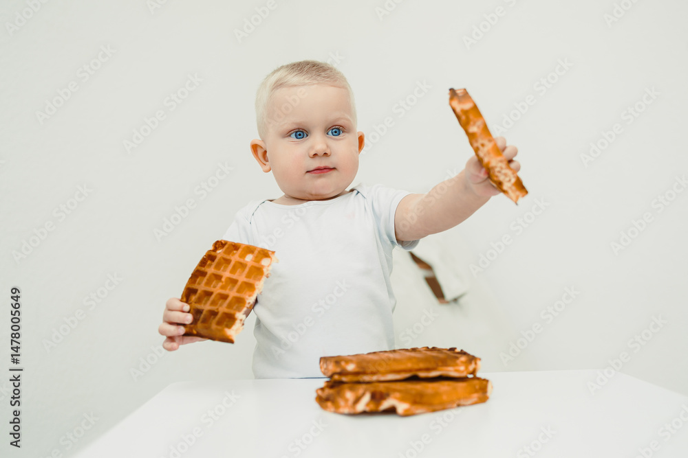 A charming baby joyfully enjoys fluffy waffles, sporting a big smile that highlights their happiness during this delightful meal, creating a moment filled with pure joy and excitement