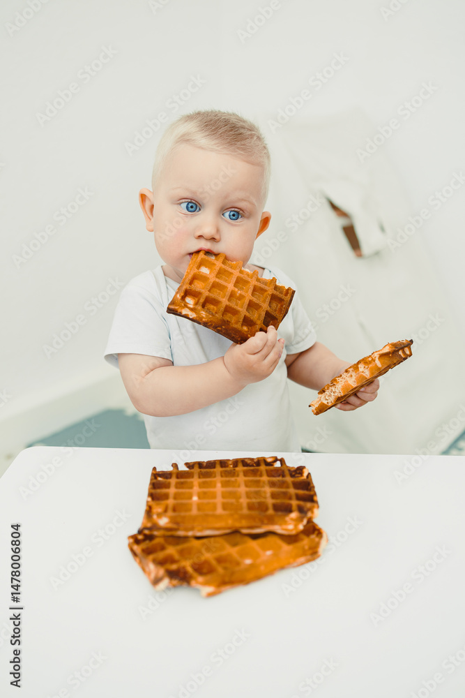 A cute little toddler is having a wonderful time enjoying some delicious waffles in a beautifully minimalistic setting that enhances the overall experience, bringing joy to breakfast time