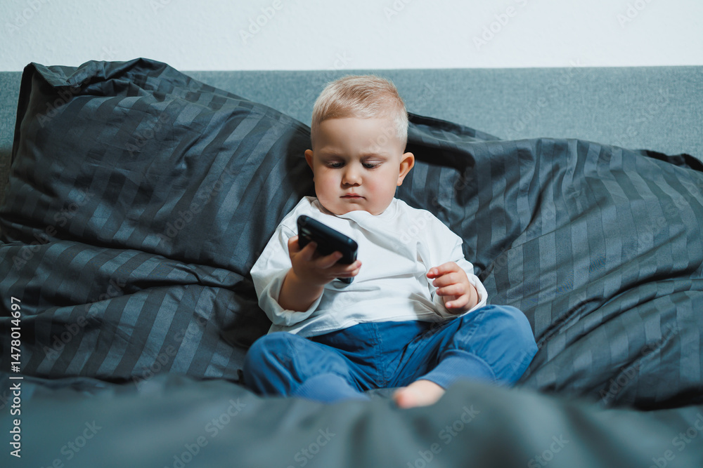 Curious Toddler Engaged with Smartphone on Cozy Sofa