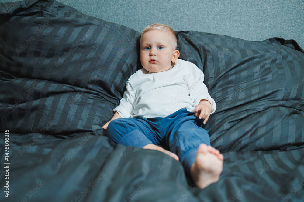 An adorable baby relaxes peacefully on a cozy bed with plush bedding in a beautifully designed modern room, capturing the true essence of childhood happiness, warmth, comfort, and joy