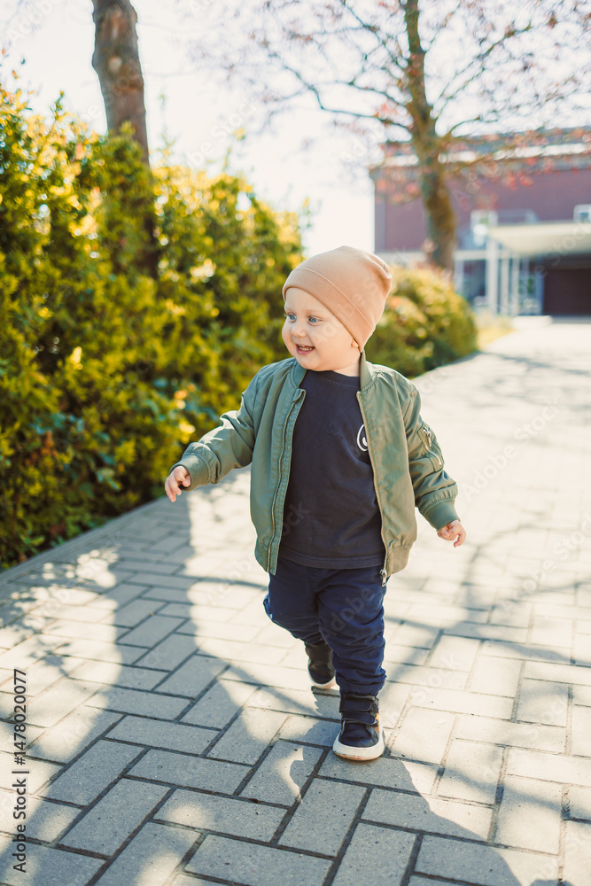 A joyful child dressed in a casual, comfortable outfit is delighting in a sunny day outdoors, soaking up the surroundings and embracing the beauty of nature with happiness all around them