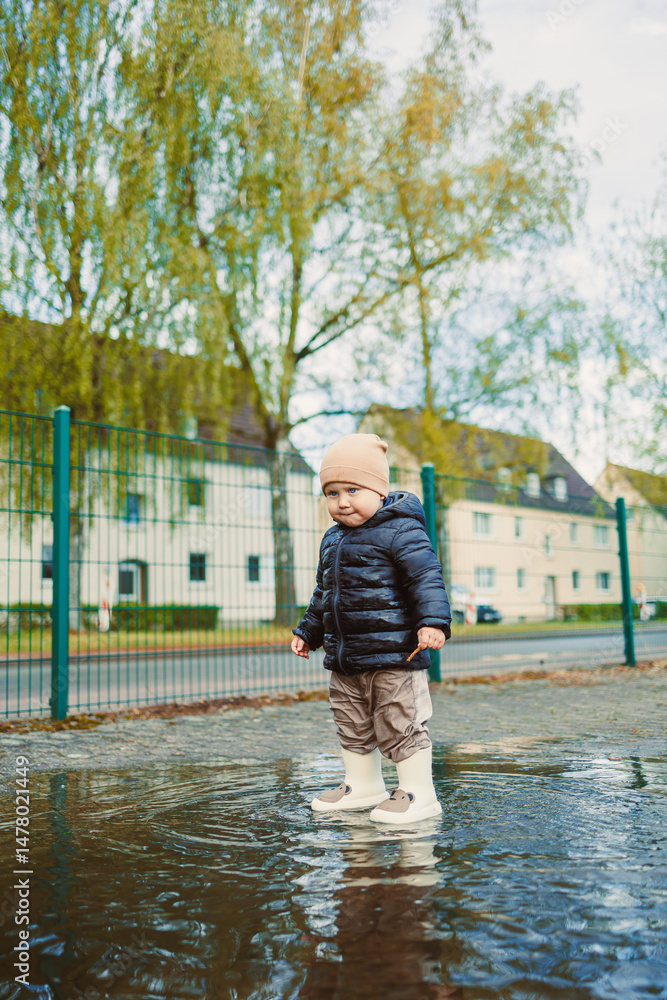 A child happily enjoying a rainy day in a puddled street Capturing the joyful and carefree moments of childhood while experiencing the beauty of nature around them in an engaging way