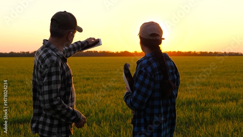 Two farmers meet in field and shake hands, demonstrating cooperation. Farmers are ready for partnership and cooperation. Teamwork of farmers contributes to development of agriculture.