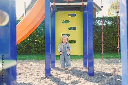 Obraz na płótnie A Young Child Enjoys Playing at the Playground Capturing Joyful Moments in a Vibrant and Colorful Outdoor Environment Filled with Laughter, Adventure, and Pure Fresh Air, Ensuring Lasting Memories w salonie
