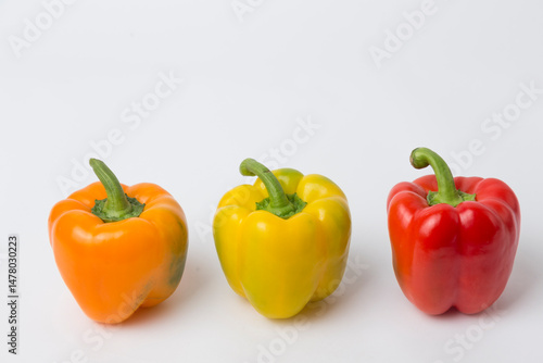 Yellow, Red, and Orange Bell Peppers on White Background
