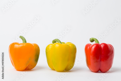 Yellow, Red, and Orange Bell Peppers on White Background
