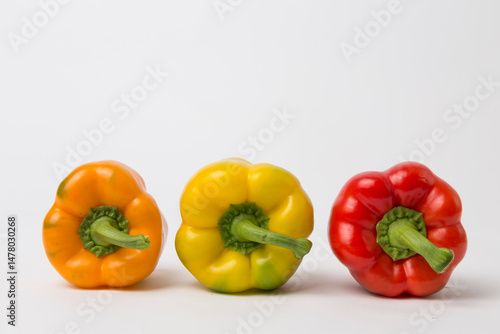 Yellow, Red, and Orange Bell Peppers on White Background