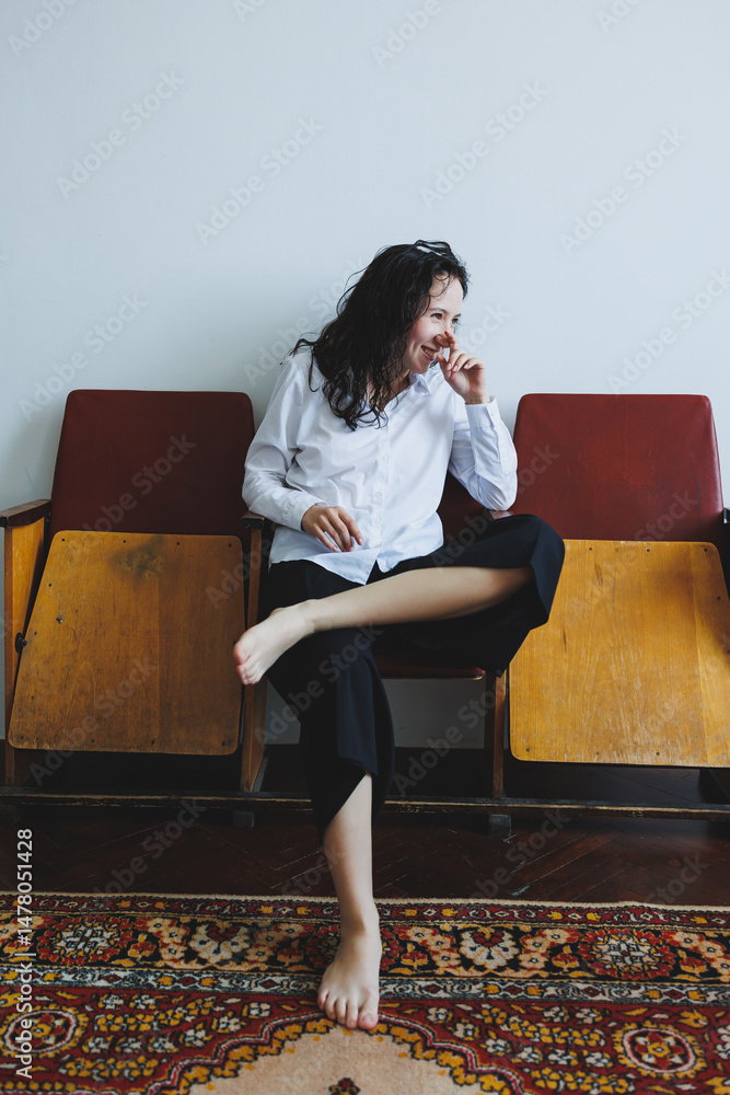 Charming and Joyful Young Woman Laughing Cheerfully in a Relaxed and Casual Outfit An Enchanting Indoor Portrait Surrounded by Vintage Chairs, Highlighting Her Playful and Happy Spirit Beautifully