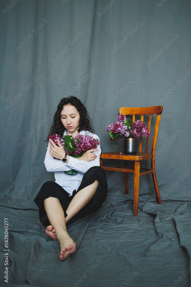 A Contemplative Woman Embracing Beautiful Flowers in a Serene Indoor Setting, Surrounded by a Calm and Peaceful Atmosphere That Enhances Her Thoughts and Emotions while She Sits on a Chair