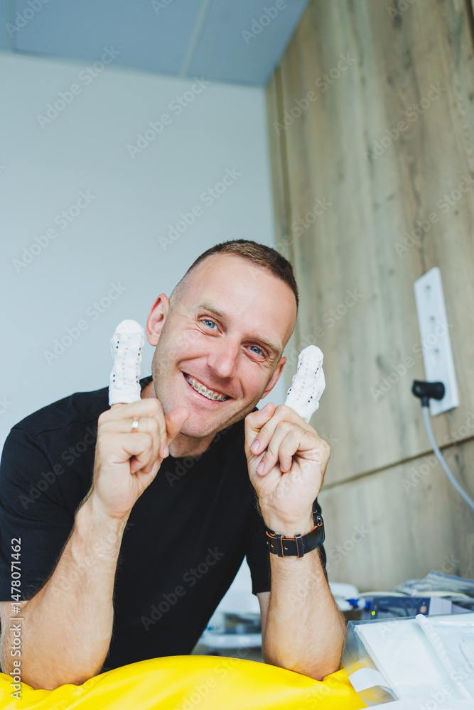 A Cheerful Man is holding fun and playful figurines in a beautifully bright room that is accented with wooden features, radiating positive energy and showcasing a vibrant atmosphere