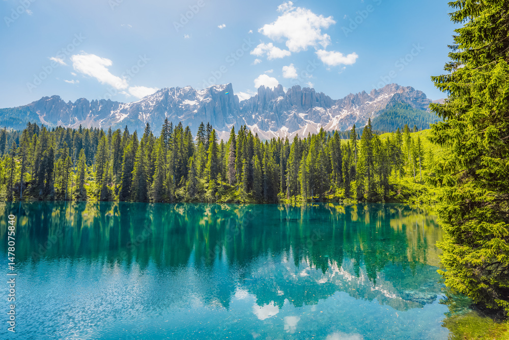 Karersee mountain lake in the Dolomites landscape, South Tyrol alps, Italy, also known lake Carezza. Reflection green on lake.