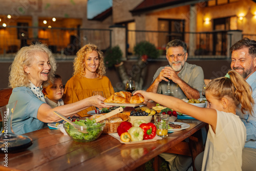 Quadro su tela Happy family enjoying outdoor dinner together at home