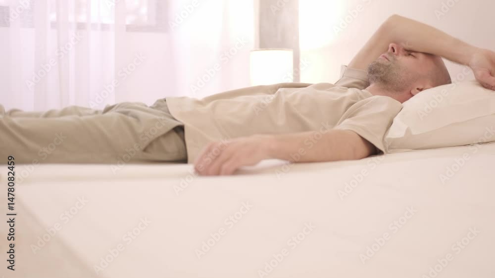 Young guy lying in bed, getting ready to sleep, falling asleep, bedtime habits, tired body, bedtime ritual, home comfort, early morning Young guy lying in bed, getting ready to sleep, falling asleep, bedtime habits, tired body, bedtime ritual, home comfort, early morning