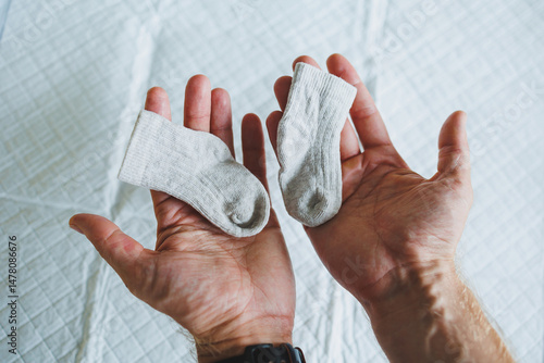 Obraz na płótnie A Tender Moment Gently Comparing Adorable Baby Socks in Their Hands This Beautiful Scene Symbolizes the Start of New Parenthood Filled with Joyful Anticipation and Loving Emotions w salonie