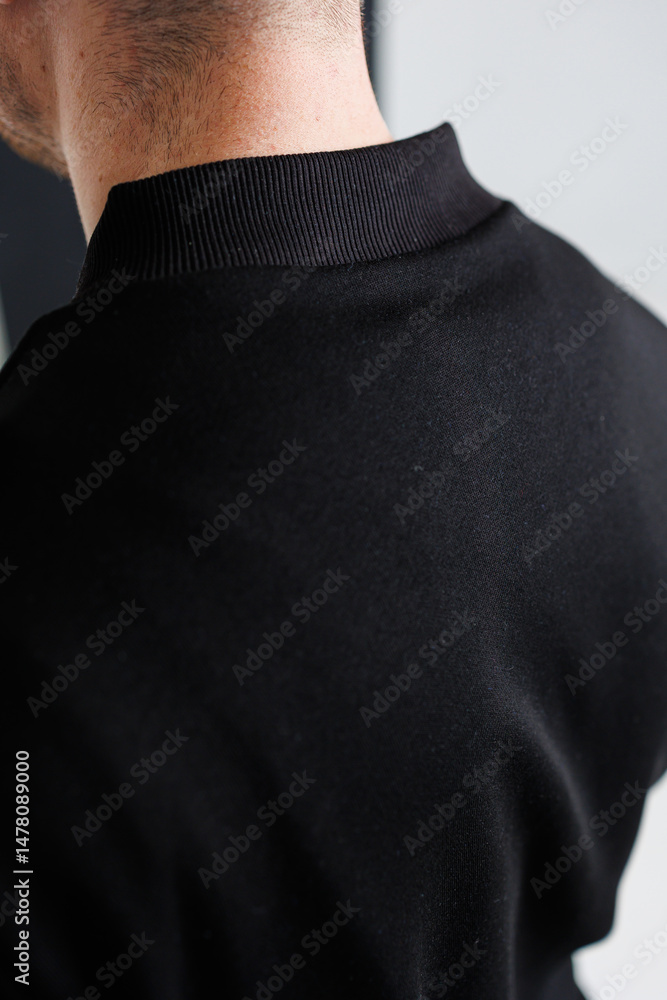 This product showcases a closeup view of a stylish mens black sports top, which features a unique and intricate stitching detail located on the back, offering both functionality and fashion appeal