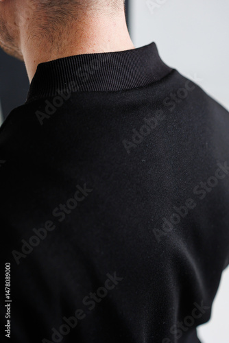 Obraz na płótnie This product showcases a closeup view of a stylish mens black sports top, which features a unique and intricate stitching detail located on the back, offering both functionality and fashion appeal w salonie