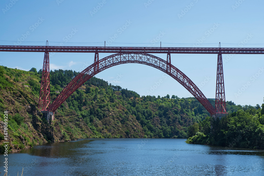 Naklejka premium Red metal Garabit Viaduct over a river in France