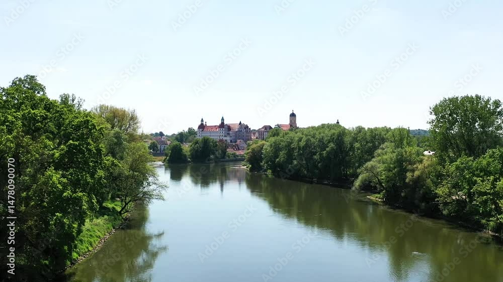 Eine beeindruckende Luftaufnahme von Neuburg an der Donau, einer malerischen Stadt in Bayern, Deutschland. Die Donau schlängelt sich durch die Stadt und bildet eine kleine Insel. Eine beeindruckende Luftaufnahme von Neuburg an der Donau, einer malerischen Stadt in Bayern, Deutschland. Die Donau schlängelt sich durch die Stadt und bildet eine kleine Insel.