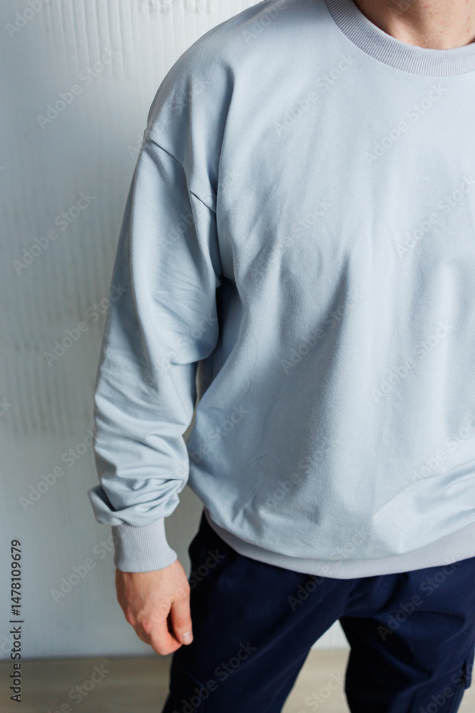Casual Contemporary Fashion A chic and stylish grey sweatshirt is beautifully worn by a model showcasing it in a minimalist setting, highlighting its modern design and versatility in everyday wear
