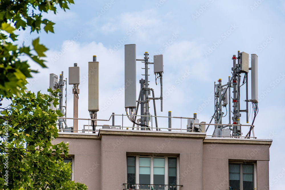 Obraz premium Antennes d'opérateurs de réseaux de téléphone mobile 4G et 5G sur le toit d'un immeuble d'habitation. Concepts de couverture du réseau mobile et de pollution électromagnétique