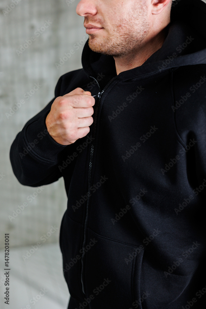 A Stylish Man in a Black Hoodie Zipping Up This serves as an excellent source of Casual Urban Fashion Inspiration that you can incorporate into your everyday wardrobe and lifestyle choices