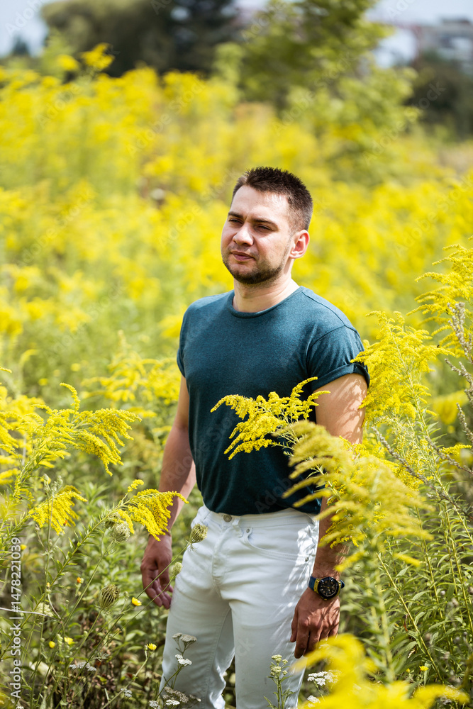 This is a striking portrait of a man set against a beautiful yellow flower field, encapsulating a moment of serene tranquility that showcases his deep connection to the natural world all around him