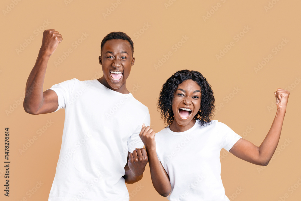 African-american partners rejoice success, clench fists and exclaim, standing next to each other on yellow studio background. Happy black couple winners celebrating success, having good news African-american partners rejoice success, clench fists and exclaim, standing next to each other on yellow studio background. Happy black couple winners celebrating success, having good news
