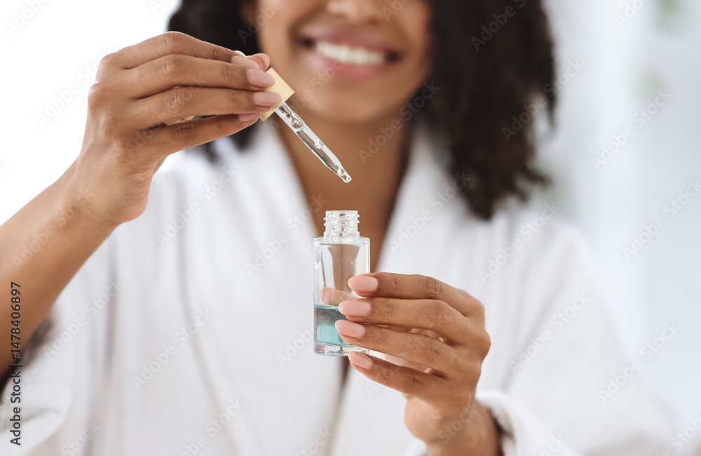 Fototapeta premium Beauty And Skincare. Smiling Black Woman Holding And Opening Bottle With Moisturizing Face Serum, Making Skin Treatment At Home, Closeup