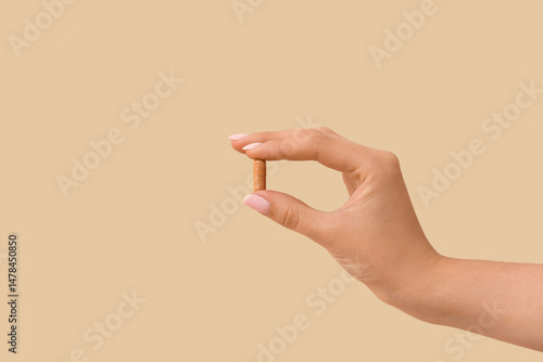 Woman holding brown pill on...