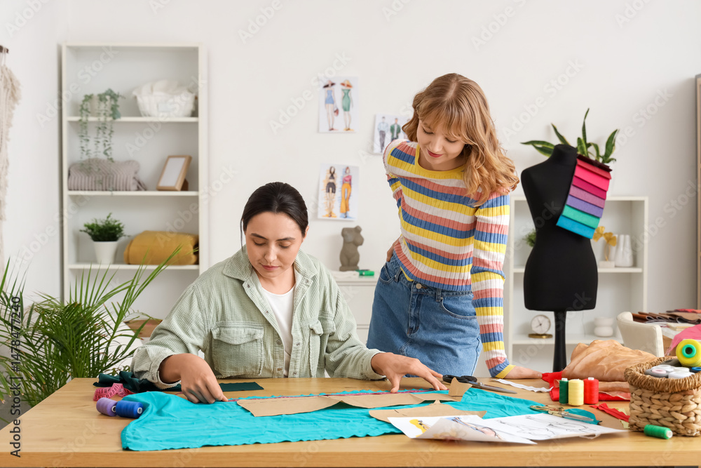 Fototapeta premium Female tailors working at table in atelier
