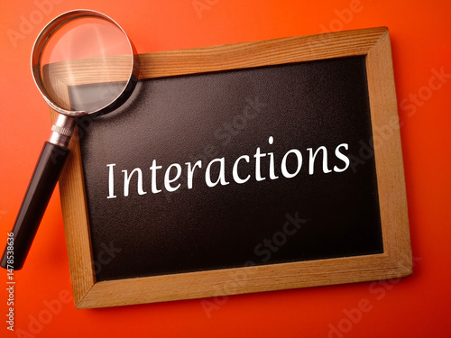 Wooden board with the word Interactions on a orange background