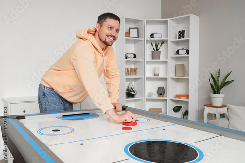 Young man playing air hocke...