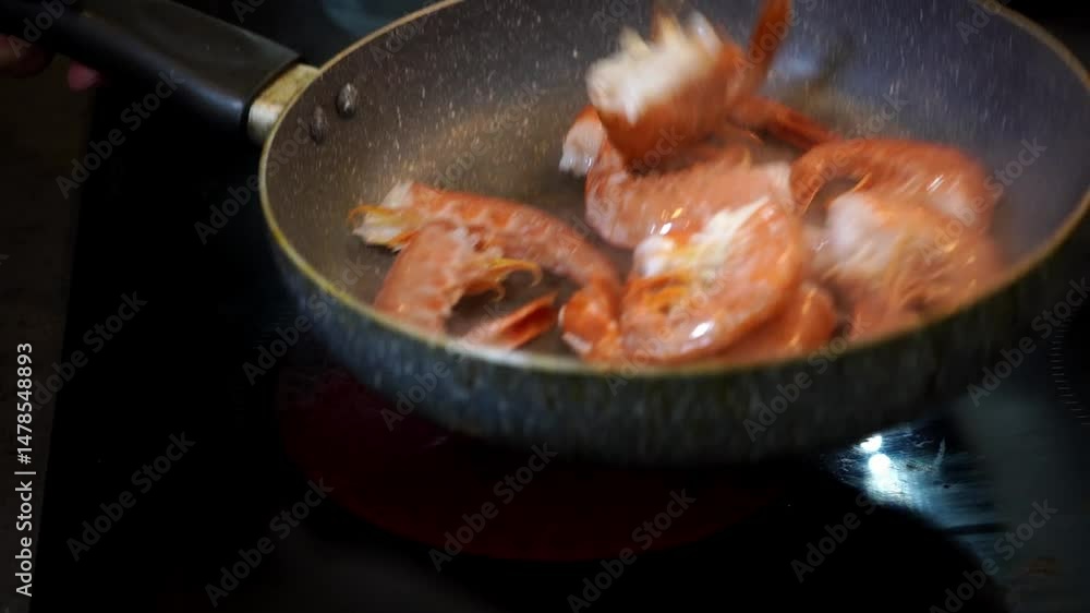 Close-up video of shrimps being cooked in a hot pan, tossed and stirred with sizzling sound and steam. A dynamic and appetizing cooking scene full of flavor and motion. Close-up video of shrimps being cooked in a hot pan, tossed and stirred with sizzling sound and steam. A dynamic and appetizing cooking scene full of flavor and motion.