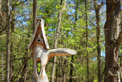 Fotografie Wooden forest elf carving points the way to wanderers seeking direction