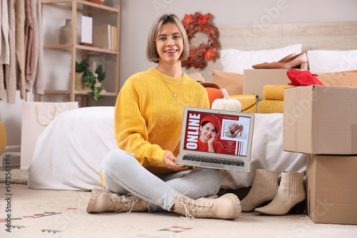 Young woman with laptop sho...