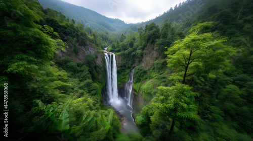 Majestic waterfall cascading through misty green valley