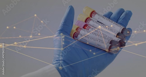 Gloved hand holding monkeypox test tubes in health research lab, displaying glowing network overlay