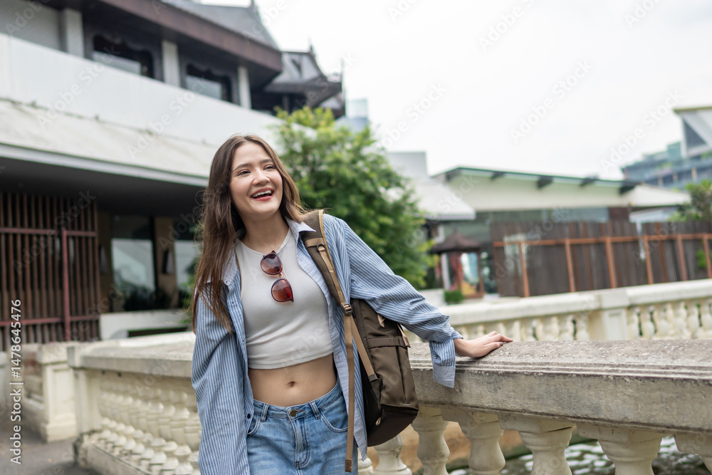 Fototapeta premium Asian young beautiful woman backpacker exploring the city outdoors.