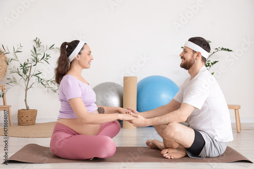 Sporty pregnant couple hold...
