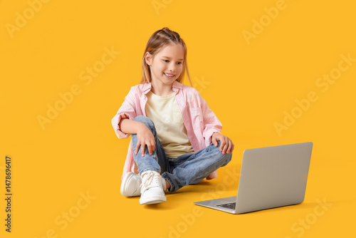 Little girl with laptop sit...