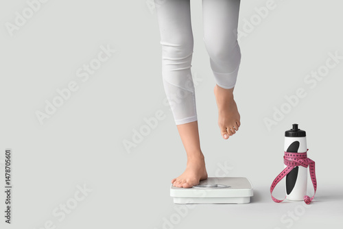 Legs of sporty woman measur...