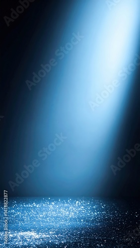 A vibrant blue spotlight beams intensely against a deep black background, creating a striking contrast that highlights the luminous glow and adds drama.