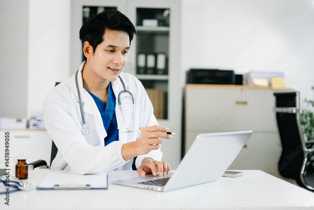 Confident male doctor pointing at laptop screen while working in medical office. Concept of digital healthcare, data analysis, Confident male doctor pointing at laptop screen while working in medical office. Concept of digital healthcare, data analysis,