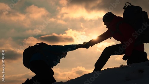 Go towards your goal. Travelers climb one after another on rock Climbers silhouettes stretch their hands to each other climbing to top of hill. Teamwork of business people. Team of businessmen victory
