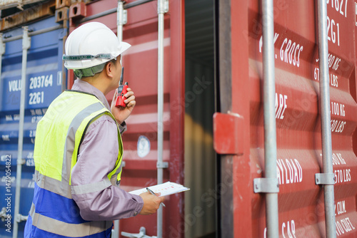 Schilderij op canvas Customs clearance officer or shipyard engineer is inspects against the import - export cargo containers