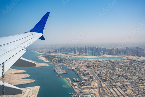 Canvas Print Aerial view of a modern coastal city seen from a plane window, showcasing the wi